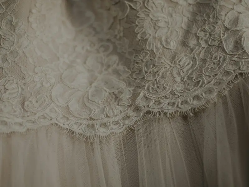 Dettaglio del pizzo e del tulle di un abito da sposa